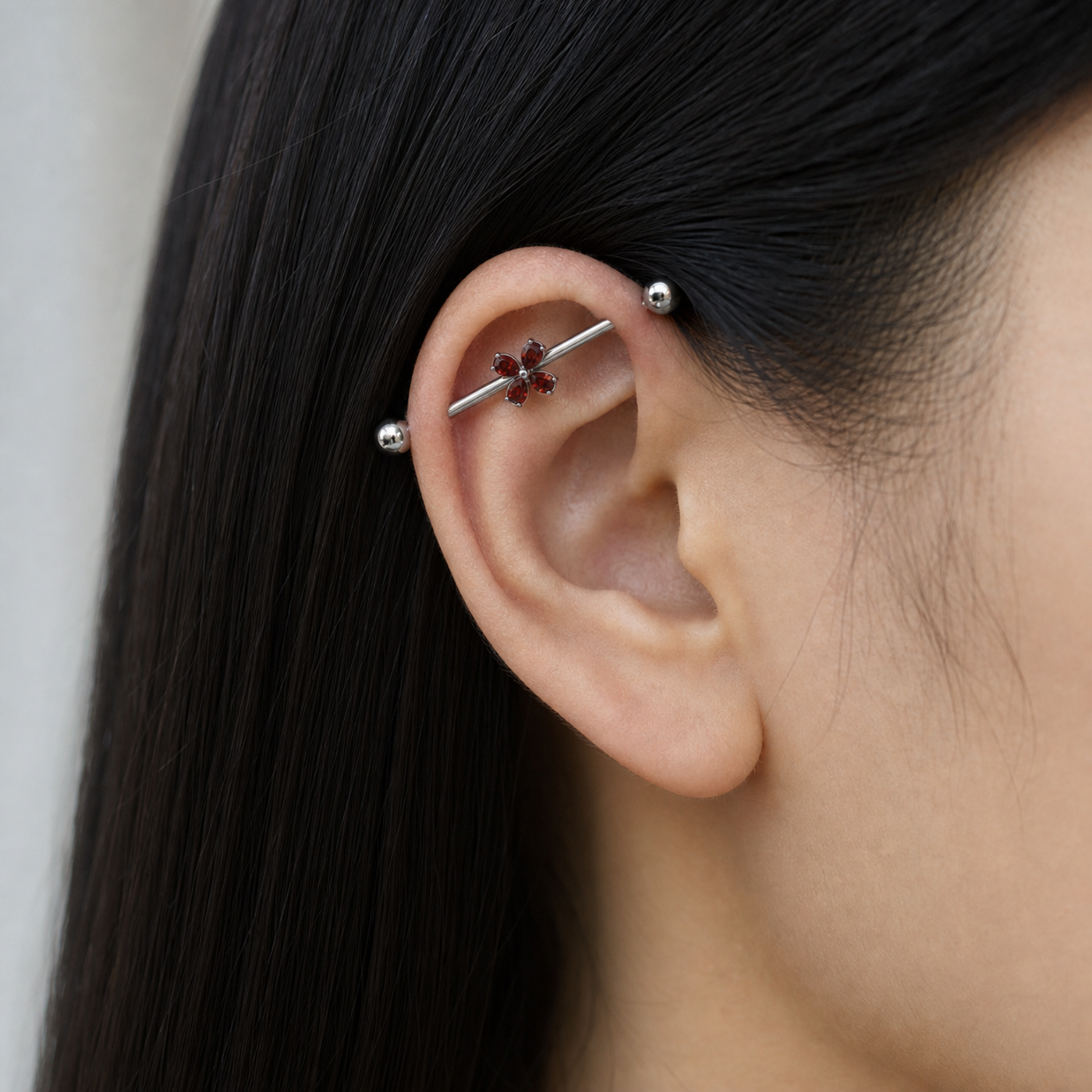 G23 Titanium Four-Petal Crystal Industrial Barbell Earring worn on ear in clean window daylight