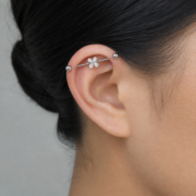 G23 Titanium Four-Petal Crystal Industrial Barbell Earring in Silver worn on ear in clean window daylight