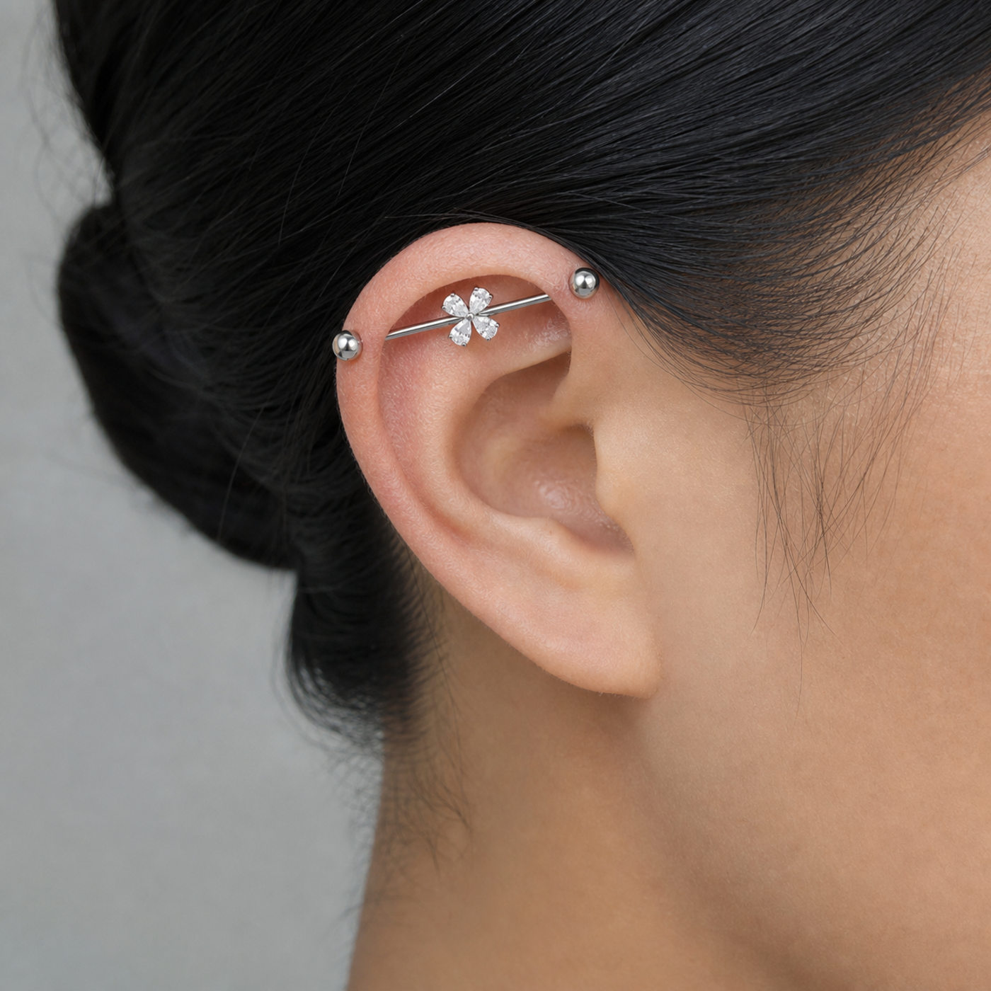 G23 Titanium Four-Petal Crystal Industrial Barbell Earring in Silver worn on ear in clean window daylight