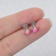 Titanium Stud Earrings Flat Round Starter for Sensitive Ears shown at fingertip scale