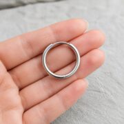 Titanium Hoop Earrings Classic Natural Titanium for Sensitive Ears shown at fingertip scale