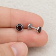 Flat Back Stud Earrings Micro Birthstone in F136 Titanium shown at fingertip scale