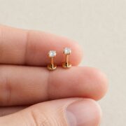 Flat Back Stud Earrings Small Solitaire in F136 Titanium shown at fingertip scale