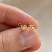 Flat Back Stud Earrings Pillow Heart in Titanium shown at fingertip scale