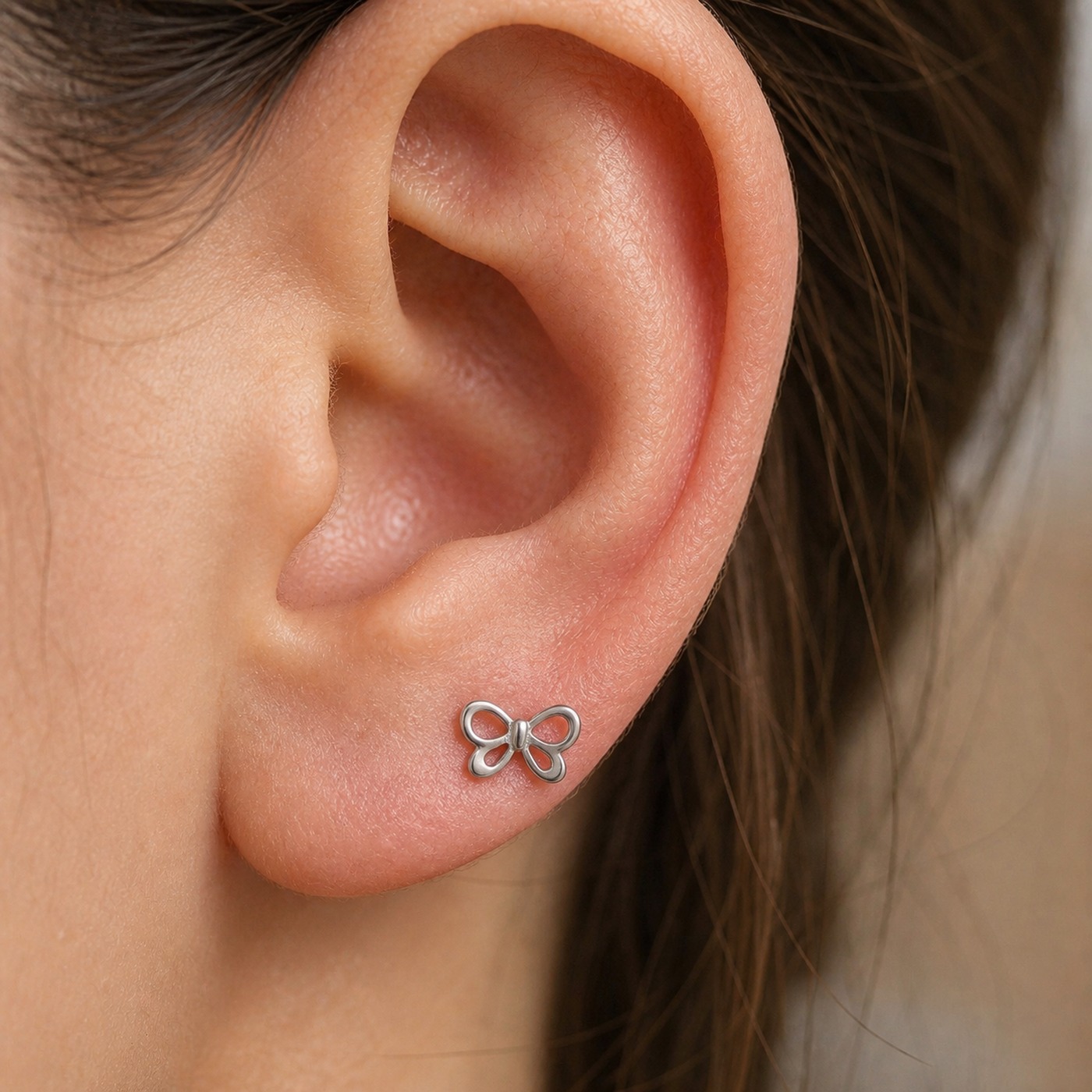 Titanium Stud Earrings Mini Bow in F136 Titanium worn on one ear