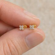 Flat Back Stud Earrings Crystal Flower in F136 Titanium shown at fingertip scale