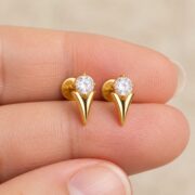 Flat Back Stud Earrings Crystal Comet in F136 Titanium shown at fingertip scale