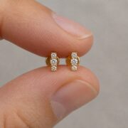 Flat Back Stud Earrings Crystal Trio Bar in F136 Titanium shown at fingertip scale