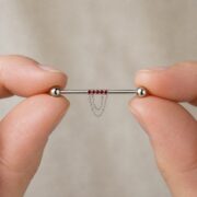 G23 Titanium Double Chain Industrial Barbell Earring shown at fingertip scale