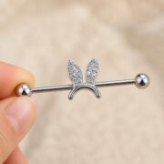 G23 Titanium Bunny Crystal Industrial Barbell Earring in Natural Titanium shown at fingertip scale