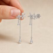 S925 Silver Floral Vine Chain Drop Stud Earrings shown at fingertip scale