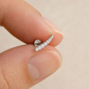 Titanium Flat Back Earrings – Graduated Zircon Arc - fingertip scale view