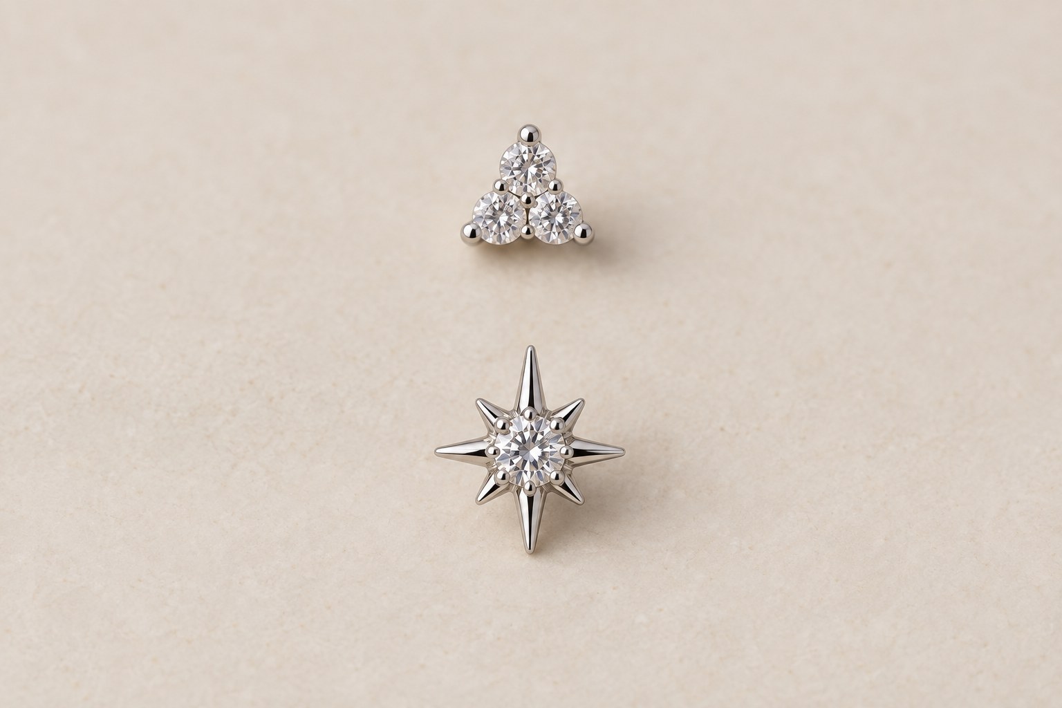 A petite crystal cluster above a larger star-shaped stud on a cream background.