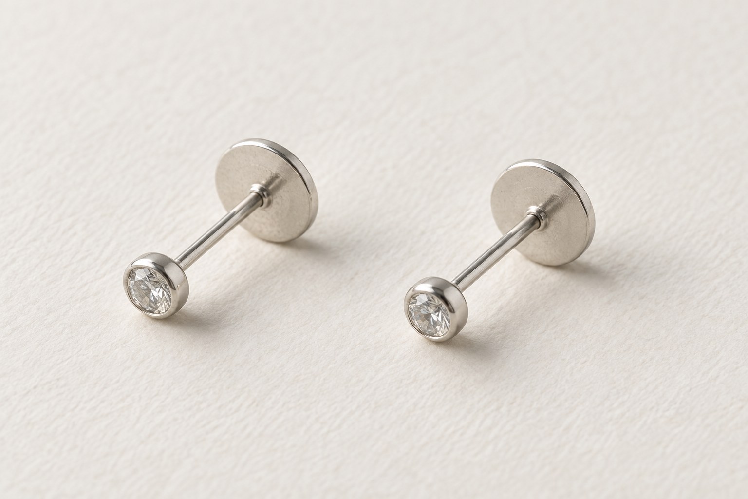 Two separate flat-back studs showing their posts and round backing disks.