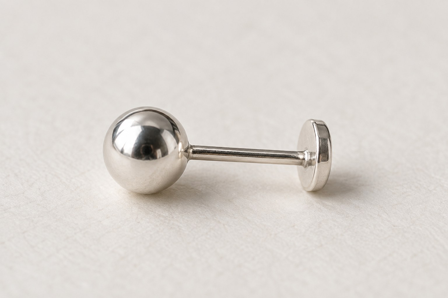 A silver-tone ball stud showing its straight post and flat rear disk.