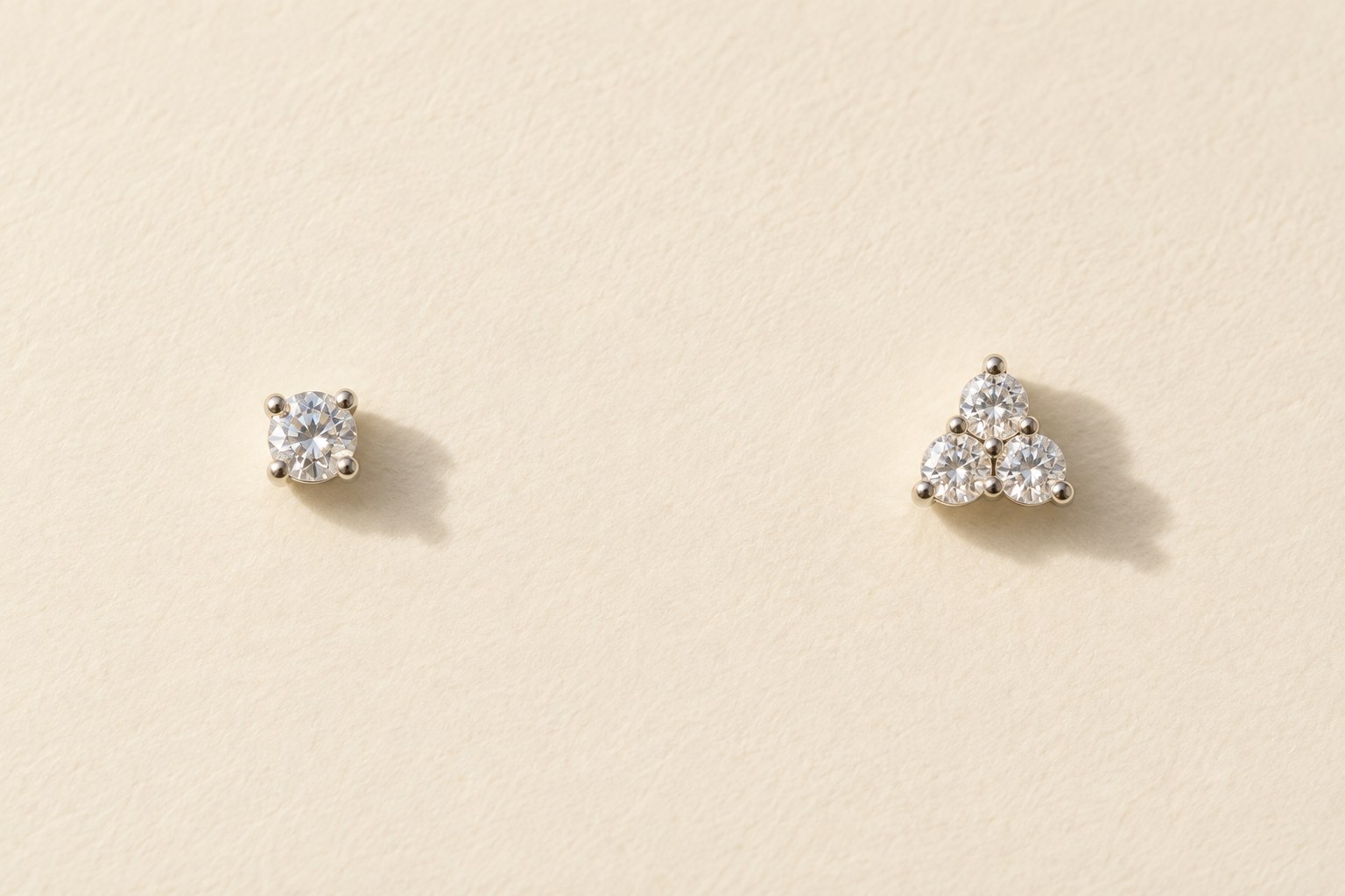 A single-crystal stud and a three-crystal cluster on cream paper.