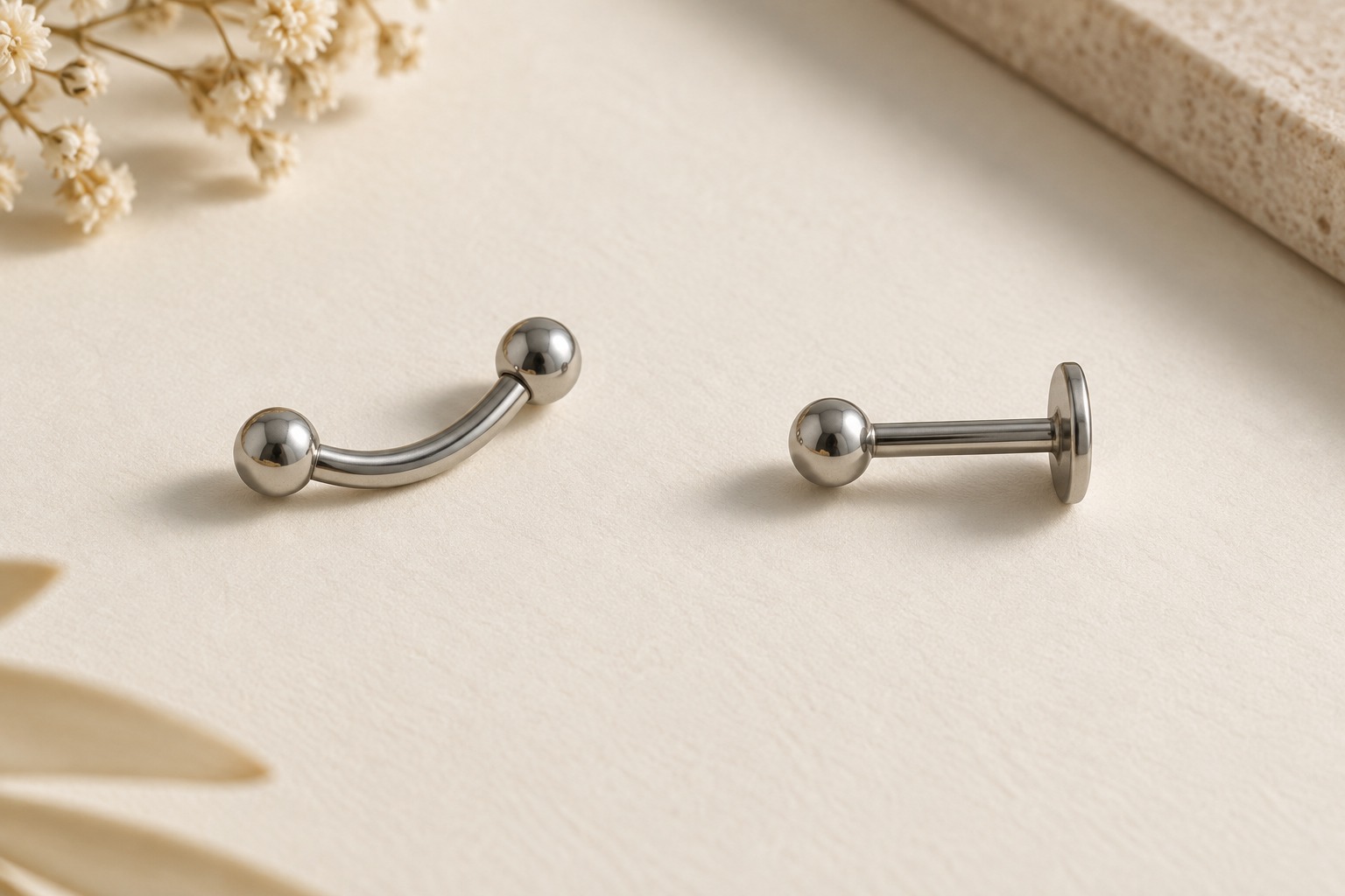 A curved barbell beside a straight post with a ball front and flat rear disk.
