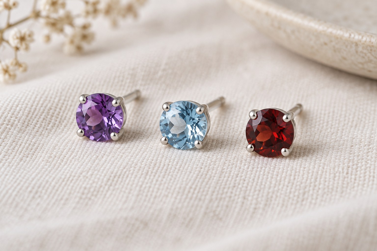 Violet, pale-blue and deep-red faceted studs on cream linen.