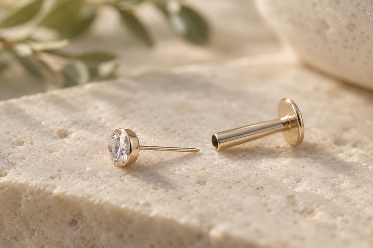 Separated push-pin front and hollow flat-back post on a neutral surface.