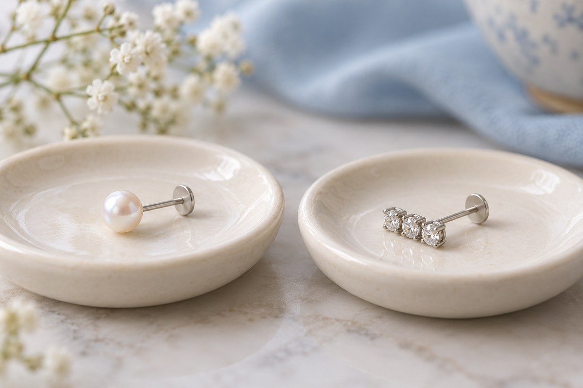 Pearl-front and crystal-bar flat-back studs lying on separate small trays.