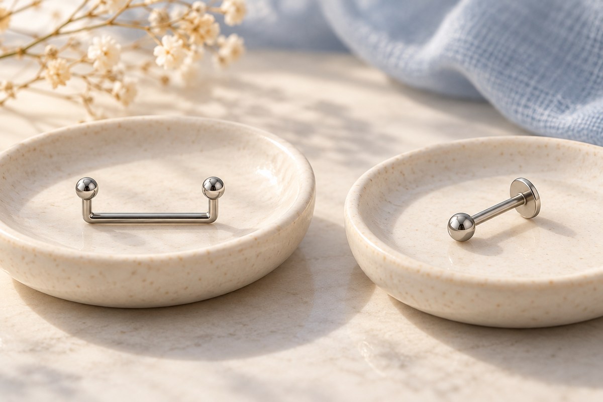 A staple-shaped surface bar and a separate straight flat-back stud on two dishes.