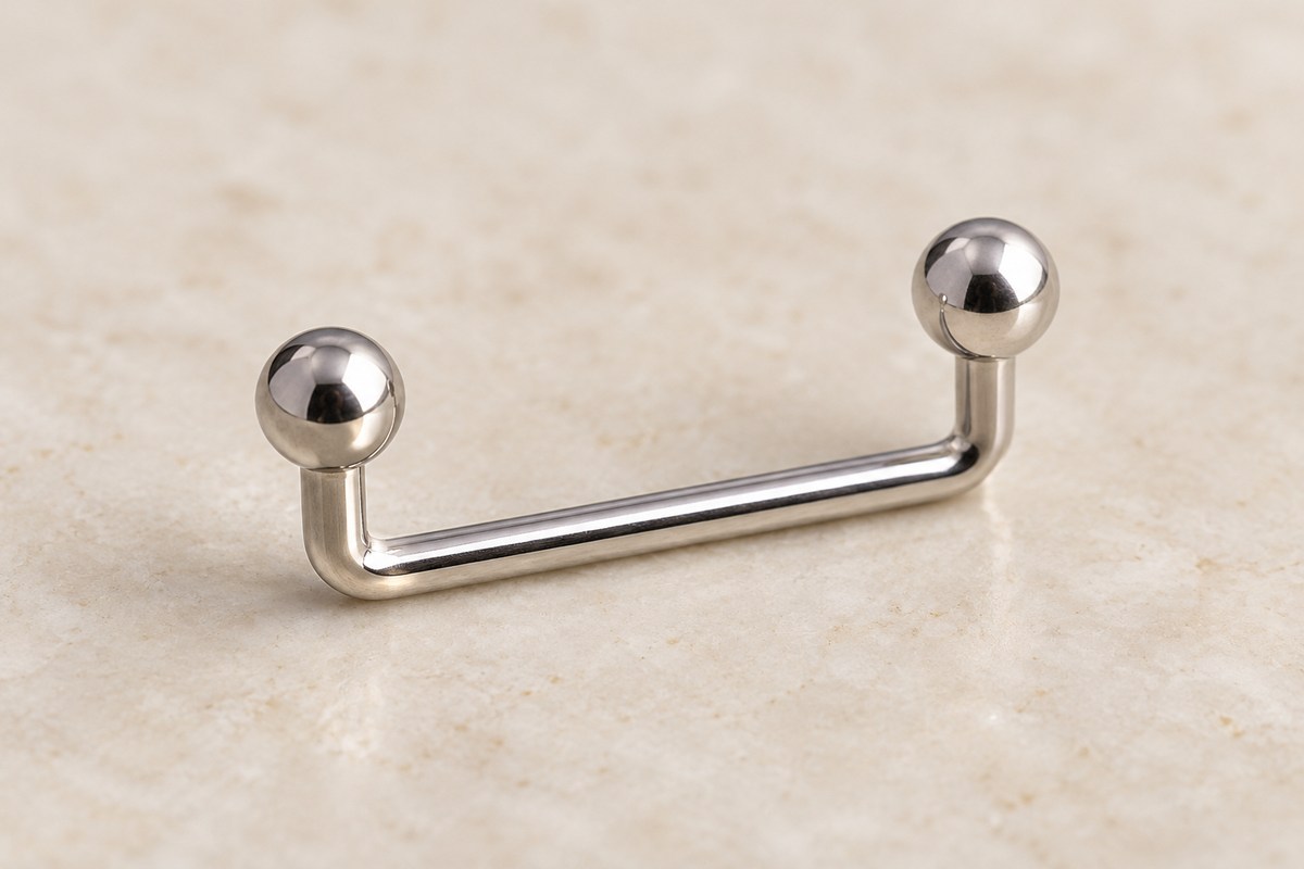 A single staple-shaped metal surface bar with two upright ends and polished ball tops.