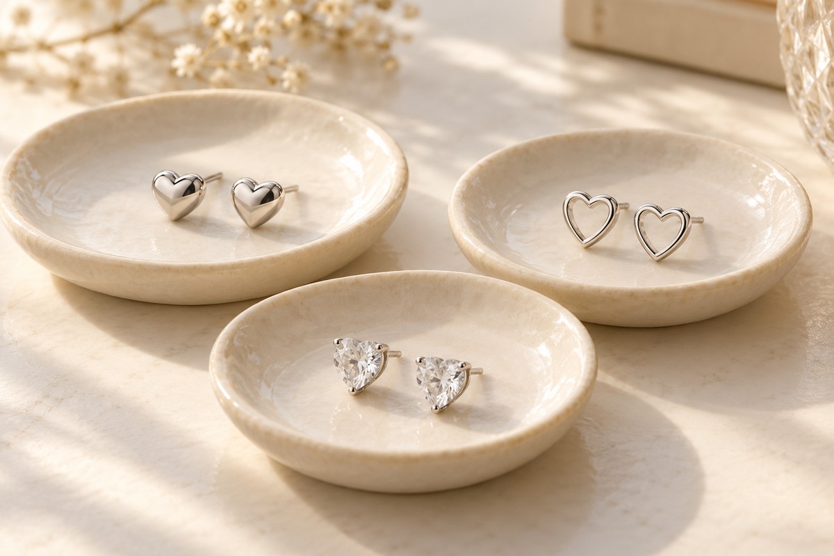 Three styles of heart stud pairs on separate ceramic dishes