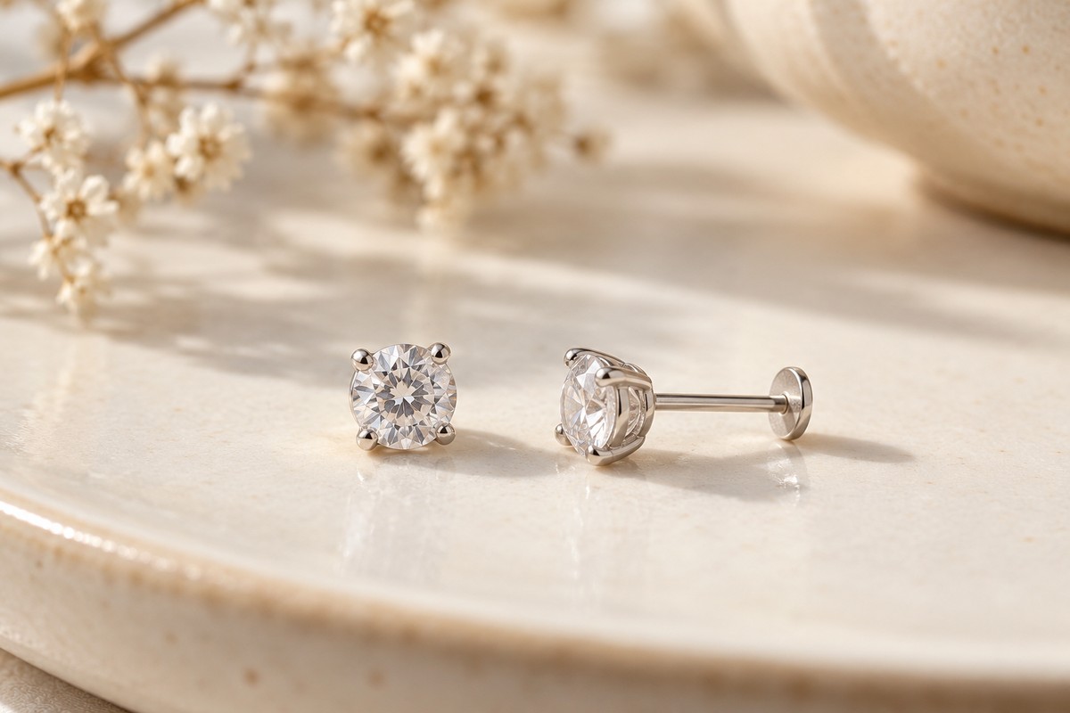 Two clear-stone studs with the side post and flat disc visible on one earring