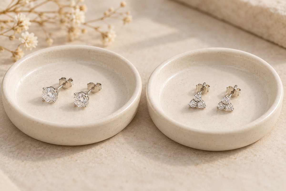 Single-stone studs and small cluster studs on separate cream trays
