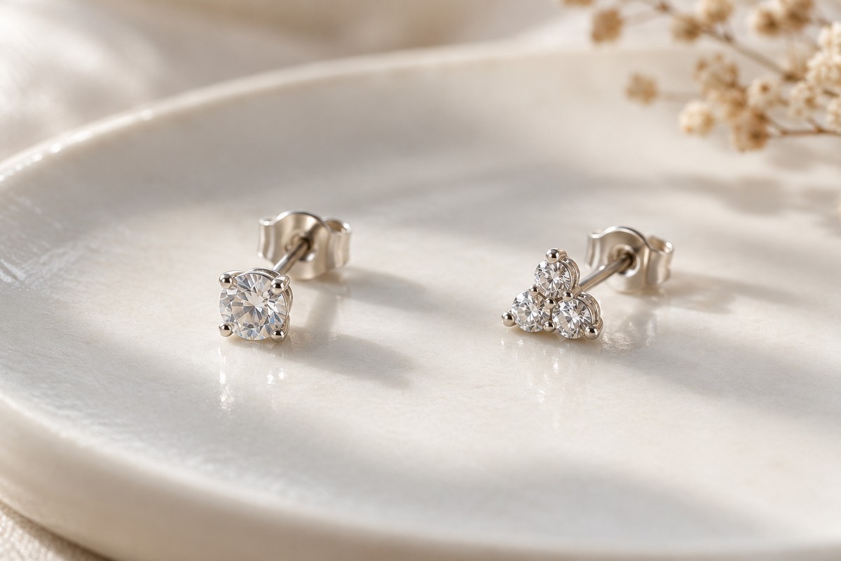 A single-stone stud beside a three-stone cluster stud