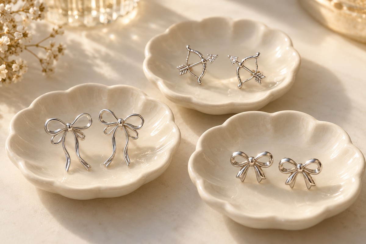 Ribbon-bow and archery-bow stud motifs arranged in three cream dishes