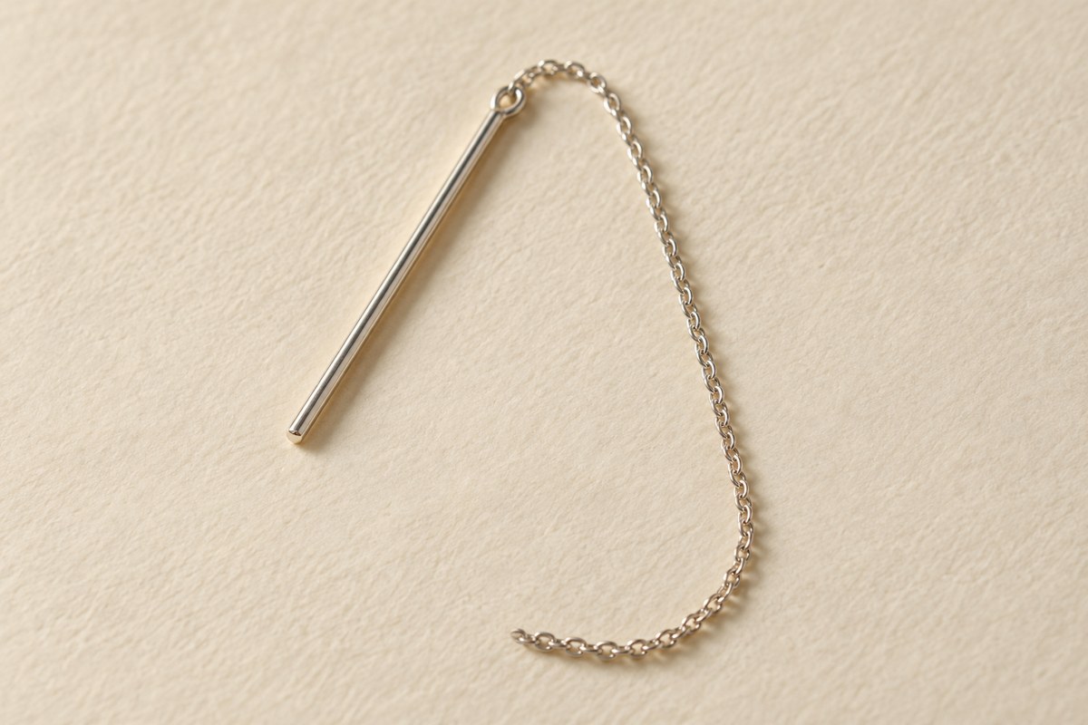 A single silver-colored threader with a straight leading end and a fine curved chain.