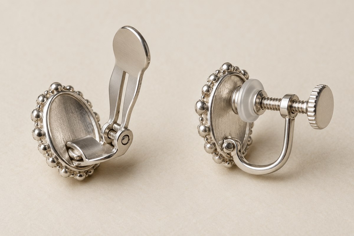 Rear views of two clip-on earrings showing a spring paddle and a U-shaped screw clip.